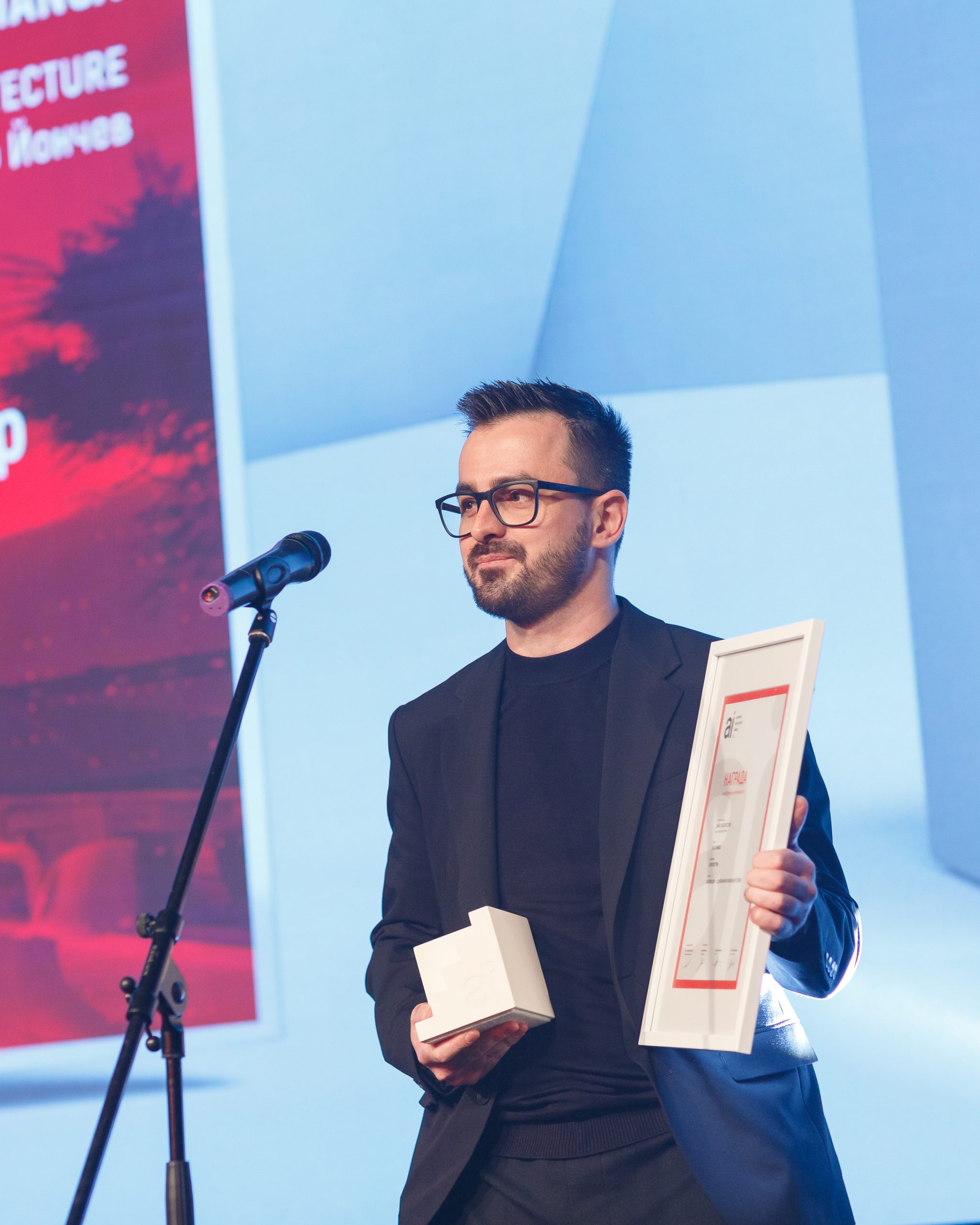 Architect Alexander Yonchev holding an architecture award for private house in Sozopol